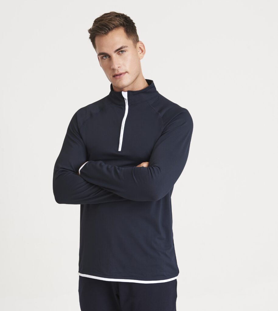 Model wearing a navy quarter-zip long-sleeve performance top with white trim details.