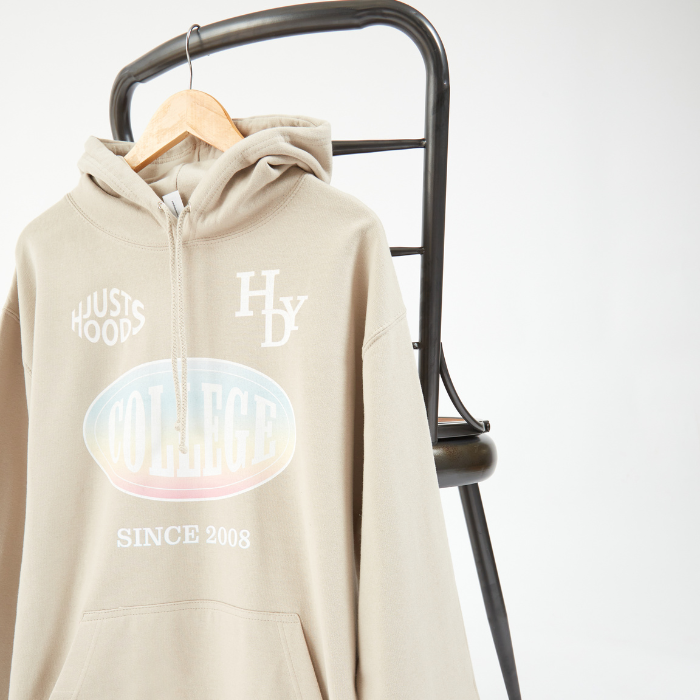 Sand coloured hoodie with printed front hanging up on a chair
