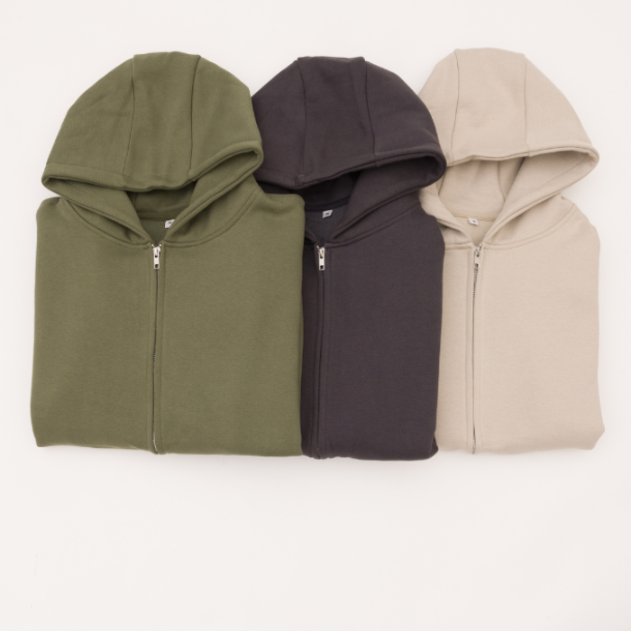 3 folded hoodies in earthy green, charcoal and desert sand,